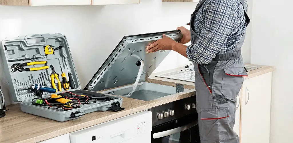 Handyman repairing a cooktop and checking wiring connections in Little Rock, AR
