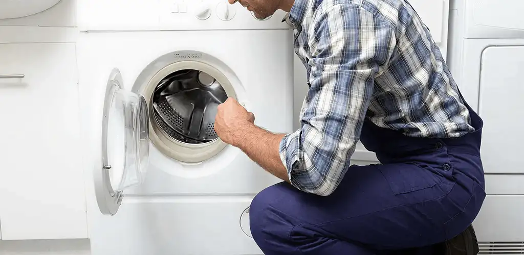 Handyman inspecting a dryer drum and internal parts for repair in Little Rock, AR