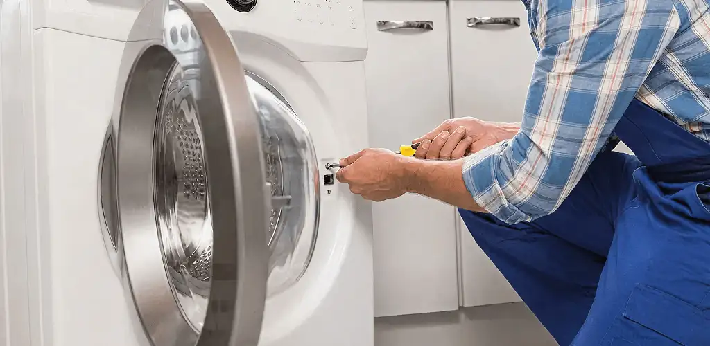 Handyman repairing a clothes dryer and checking electrical connections in Little Rock, AR
