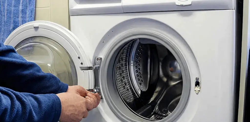 Washing machine repair handyman checking a front-load washer door and latch in Little Rock, AR