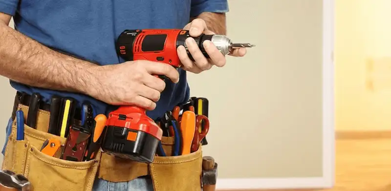 Handyman holding a power drill for home repairs and installations in Little Rock, AR