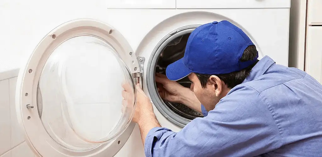 Washing machine repair handyman inspecting a front-load washer drum in Little Rock, AR